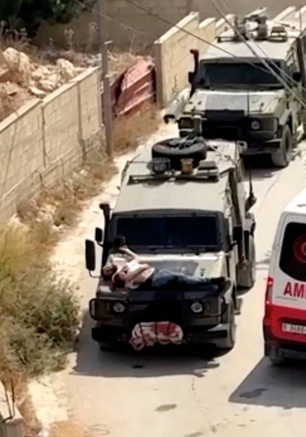 القوات الإسرائيلية تقيد رجلا فلسطينيا مصابا فوق مقدمة عربة جيب عسكرية تابعة لهم خلال مداهمة في جنين بالضفة الغربية المحتلة